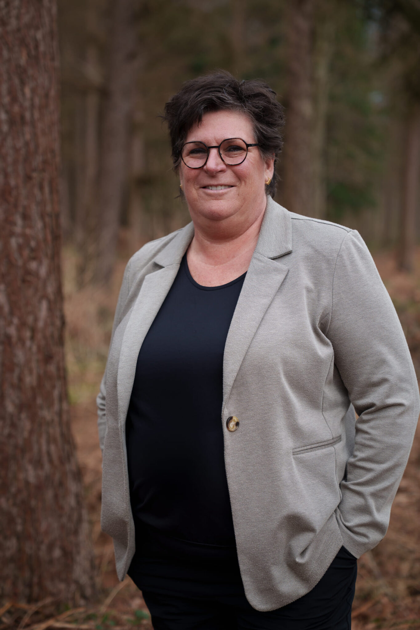 Professionele portretfoto van een persoon in een natuurlijke omgeving, passend bij Manuele Therapie Prinsenbeek.