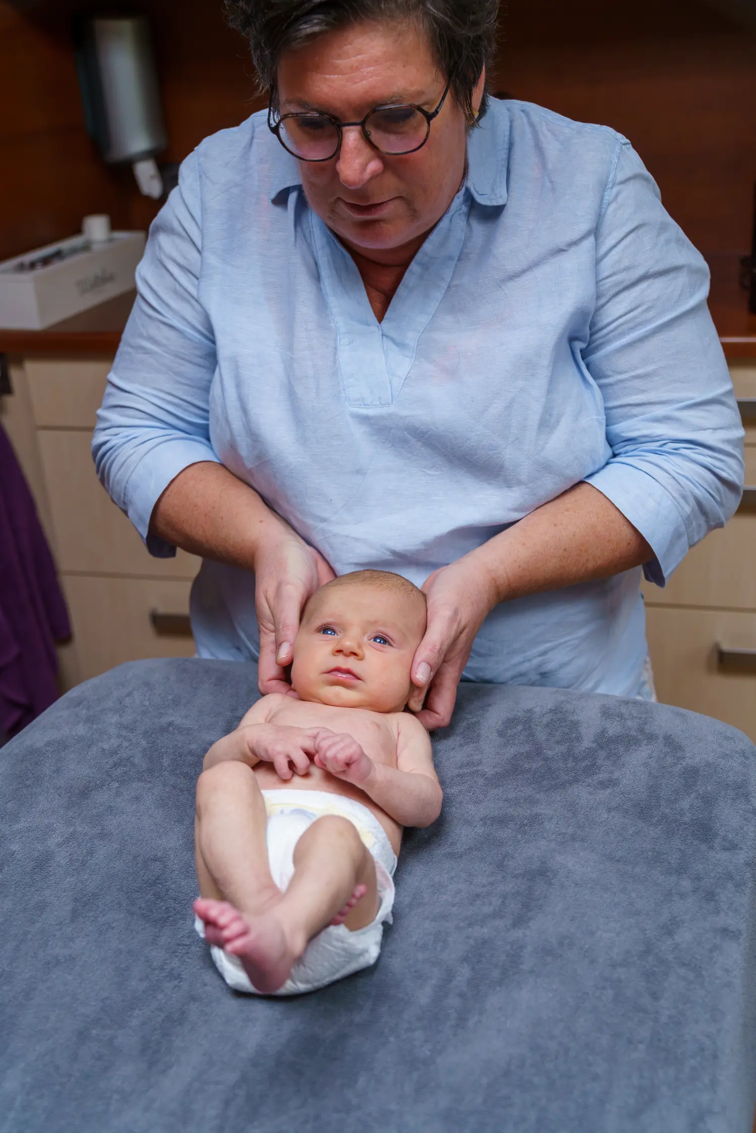 Therapeut ondersteunt baby tijdens een sessie bij Manuele therapie Prinsenbeek. Focus op zachte zorg en aandacht.